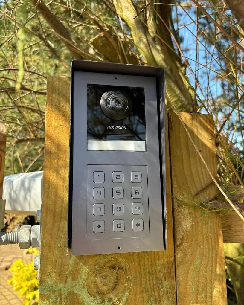 HIKVISION video door entry keypad installed at a gate post
